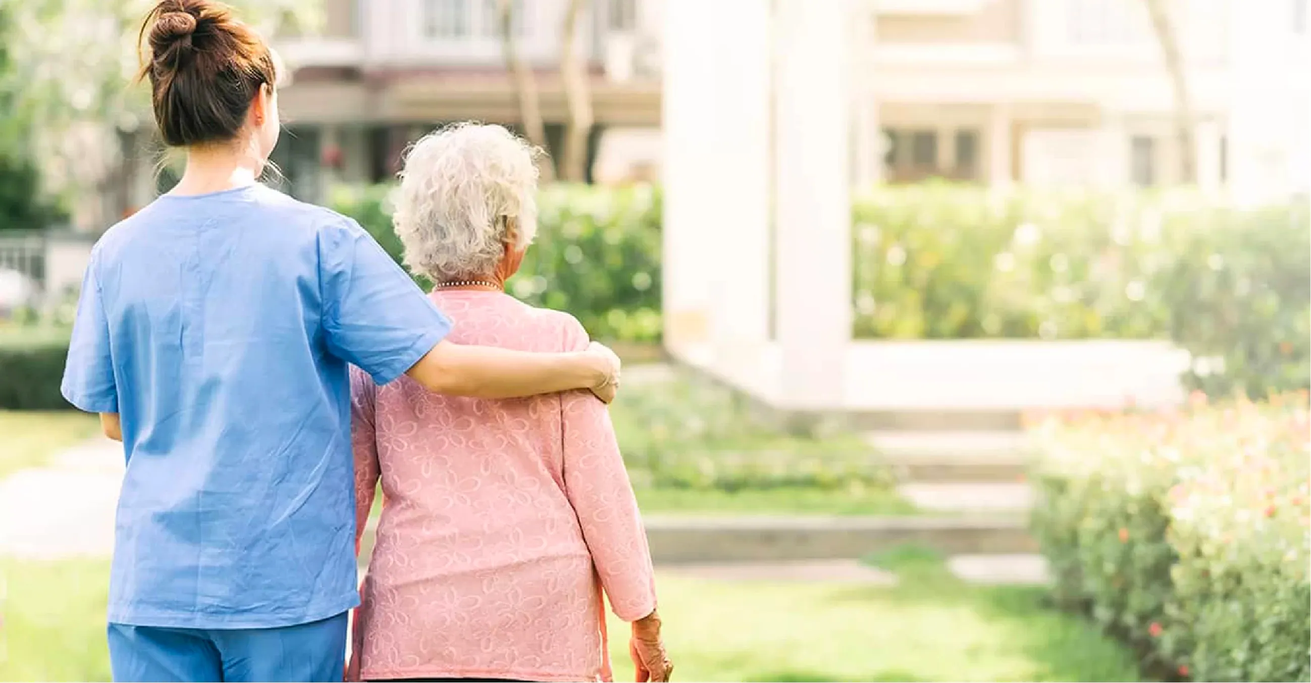 Enfermera caminando con persona de tercera edad